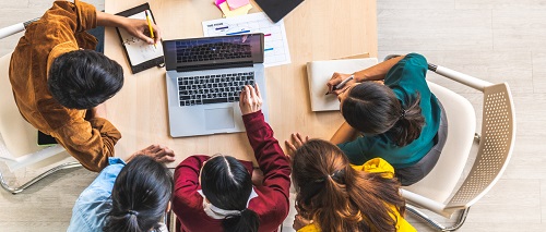 Top View of People Sitting at table looking at laptop screen