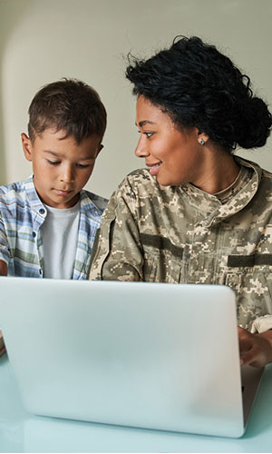 Soldier and child on laptop